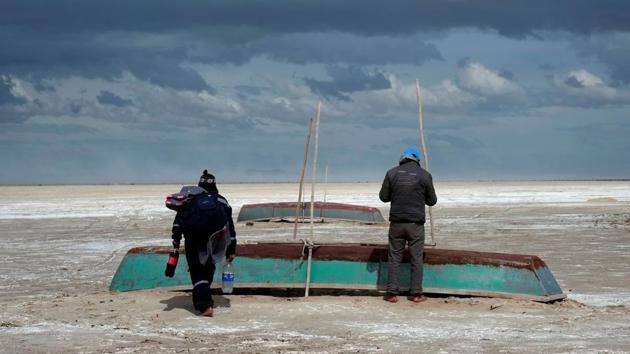 Fishermen and their boats are seen, where a slight water recovery is observed at Poopo Lake, Oruro, Bolivia. (David Mercado / REUTERS)