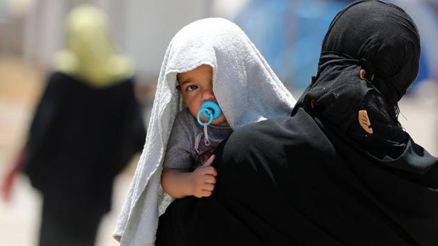 A picture taken on June 5, 2017 shows a displaced Iraqi woman carrying a child at the Al-Khazir camp for internally displaced people, located between Arbil and Mosul. Tired and traumatised, Iraqi mothers who fled Mosul struggle to breastfeed or buy baby formula milk for their babies. / AFP PHOTO / KARIM SAHIB (AFP File Photo) A picture taken on June 5, 2017 shows a displaced Iraqi woman carrying a child at the Al-Khazir camp for internally displaced people, located between Arbil and Mosul. Tired and traumatised, Iraqi mothers who fled Mosul struggle to breastfeed or buy baby formula milk for their babies. / AFP PHOTO / KARIM SAHIB (AFP File Photo)