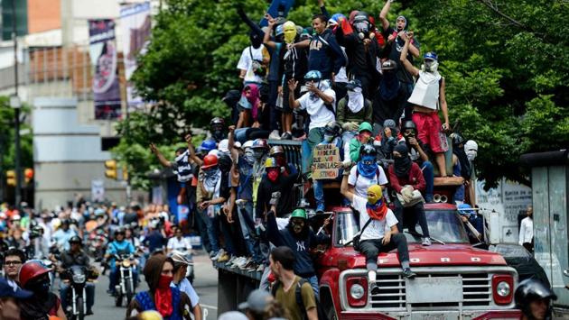 Venezuelan students and other opposition demonstrators protest outside the National Telecommunications Commission (CONATEL) to demand an end to media censorship in the country, in Caracas. Clashes at daily protests by demonstrators calling for Maduro to quit have left 66 people dead since April 1, prosecutors say. (FEDERICO PARRA /AFP)