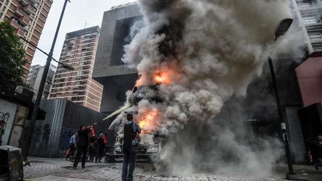 Employees of the administration headquarters of the Supreme Court of Justice try to put out the fire of a burning vehicle during a demo in Caracas. The head of the Venezuelan military, General Vladimir Padrino Lopez, who is also President Nicolas Maduro's defence minister, is warning his troops not to commit "atrocities" against protesters demonstrating in the country's deadly political crisis. Tuesday's warning came after more than two months of violent clashes between protesters and security forces. The opposition and a press rights group say security forces have run over, attacked and robbed protesters and journalists. (JUAN BARRETO / AFP)