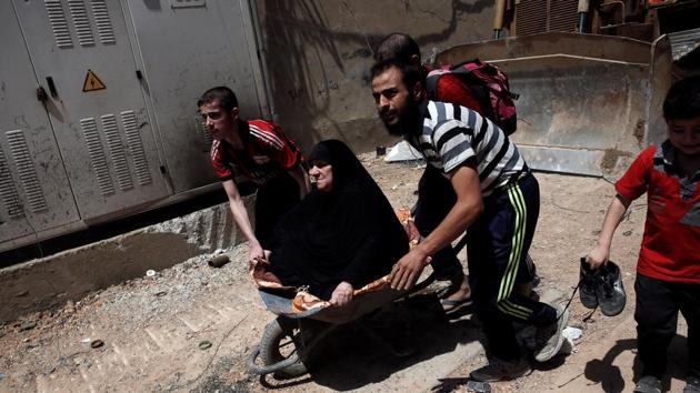 An elderly Iraqi woman is carried off in a wheelbarrow as civilians displaced by fighting between the Iraqi forces and Islamic State flee the al-Zanjili district in Mosul, Iraq. (Alkis Konstantinidis / REUTERS)