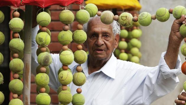 It was in the early 1960s that he began to clear a little forest patch near Sukhna Lake to create a small garden.  Here he seems to be holding up a string of old tennis balls from a creation at Chandigarh lawn tennis association’s complex in Sector 10.  (HT File Photo) 