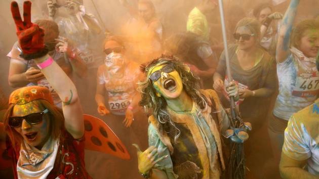 Runners covered in coloured powder celebrate after taking part in the 2017 Color Run at the Luzhniki Olympic Complex in Moscow . Started in 2011, the Colour Run is a five kilometre paint race without winners nor prizes, while runners are showered with colored powder at stations along the run.  (Maxim ZMEYEV / AFP) 
