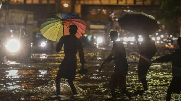 People walk through a water-logged street as it rains at Sion in Mumbai on Monday (Kunal Patil/HT Photo) People walk through a water-logged street as it rains at Sion in Mumbai on Monday (Kunal Patil/HT Photo)