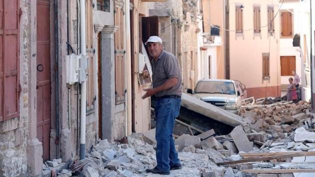A man stands among damaged buildings at Vrissa , after a strong earthquake shook the eastern Aegean. (Giorgos Moutafis / Reuters ) 