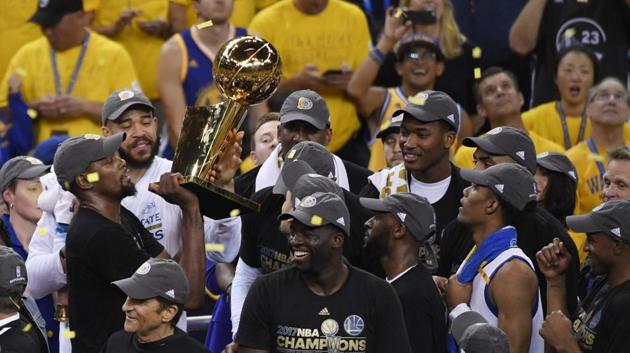 Golden State Warriors forward Kevin Durant hoists the Larry O'Brien Trophy after defeating the Cleveland Cavaliers in game five of the 2017 NBA Finals at Oracle Arena. (Kyle Terada-USA TODAY Sports)