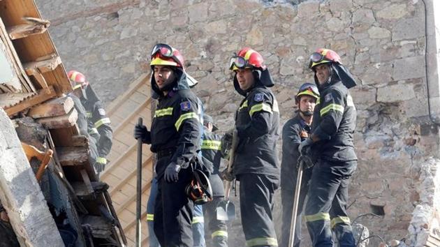 Rescue team members search for victims under a  collapsed building. (Giorgos Moutafis / Reuters ) 