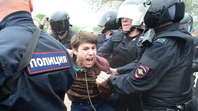 TOPSHOT - Russian police officers detain a participant of an unauthorized opposition rally in Saint Petersburg on June 12, 2017. Over 200 people were detained on June 12, 2017 by police at opposition protests called by Kremlin critic Alexei Navalny, said a Russian NGO tracking arrests. "About 121 people were detained in Moscow up to this point. In Saint-Petersburg - 137," OVD-Info group, which operates a detention hotline, wrote on Twitter. / AFP PHOTO / OLGA MALTSEVA (Olga Maltseva/AFP) TOPSHOT - Russian police officers detain a participant of an unauthorized opposition rally in Saint Petersburg on June 12, 2017. Over 200 people were detained on June 12, 2017 by police at opposition protests called by Kremlin critic Alexei Navalny, said a Russian NGO tracking arrests. "About 121 people were detained in Moscow up to this point. In Saint-Petersburg - 137," OVD-Info group, which operates a detention hotline, wrote on Twitter. / AFP PHOTO / OLGA MALTSEVA (Olga Maltseva/AFP)