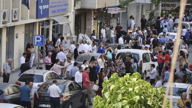 People gather outside an office building following an earthquake in the coastal city of Izmir, Turkey. (Mehmet Ozdogru / AP) 