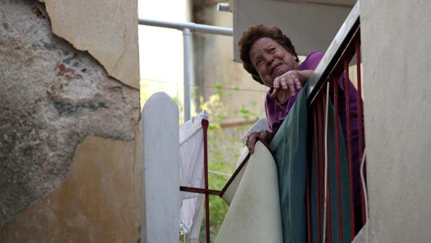 A woman reacts as she stands on her balcony at the village of Plomari. (Elias Marcou / REUTERS) 
