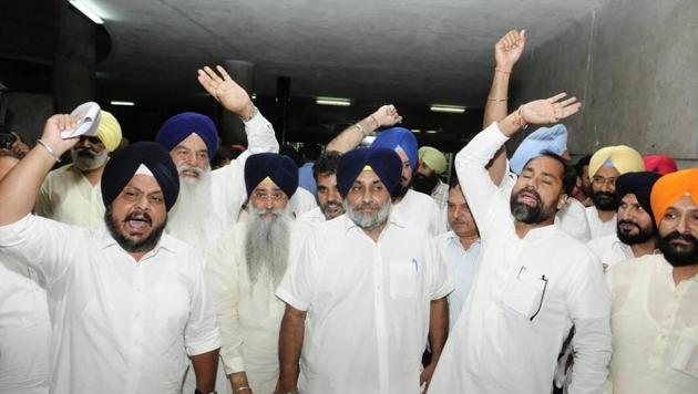 Shiromani Akali Dal president Sukhbir Singh Badal (centre) and other party MLAs walk out of the Punjab assembly to protest obituary reference to former DGP KPS Gill.(Keshav Singh/HT Photo)