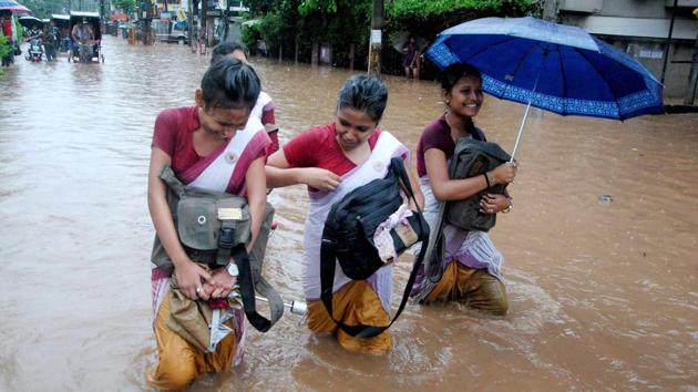 School girls make their way through a flooded street after heavy rainfall in Guwahati, Assam. (PTI) School girls make their way through a flooded street after heavy rainfall in Guwahati, Assam. (PTI)
