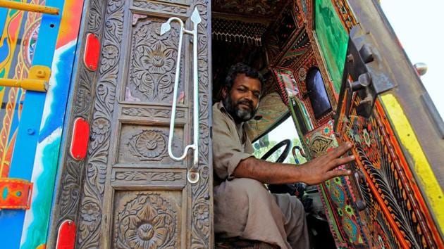 A driver holds the door of the carved wood cabin of his truck. (Caren Firouz/REUTERS)