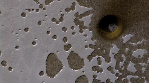 An Impact Crater : This observation from NASA’s Mars Reconnaissance Orbiter show it is late summer in the Southern hemisphere, so the sun is low in the sky and subtle topography is accentuated in orbital images.