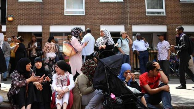 People affected by the fire that ripped through Grenfell Tower, a residential block sit on the pavement outside a temporary aid centre in west London on June 14, 2017. At least six people were killed Wednesday when a massive fire tore through a London apartment block overnight, with survivors voicing anger over longstanding safety fears at the 24-storey Grenfell Tower. (AFP) People affected by the fire that ripped through Grenfell Tower, a residential block sit on the pavement outside a temporary aid centre in west London on June 14, 2017. At least six people were killed Wednesday when a massive fire tore through a London apartment block overnight, with survivors voicing anger over longstanding safety fears at the 24-storey Grenfell Tower. (AFP)