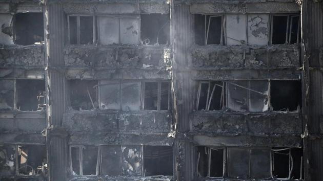 Remains of furniture are seen through windows as smoke still emerges from the burnt down Grenfell Tower in London, Thursday, June 15.(AP Photo)