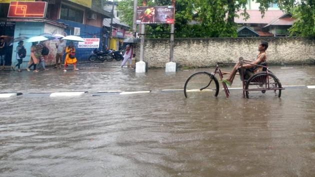 A disabled person wading through a flooded street after heavy rainfall in Guwahati, Assam on Tuesday. (PTI) A disabled person wading through a flooded street after heavy rainfall in Guwahati, Assam on Tuesday. (PTI)