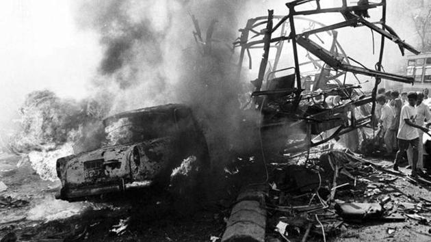 The skeletal remains of a bus seen alongside burning vehicles outside the passport office after a massive explosion in Mumbai in 1993.(AP File)
