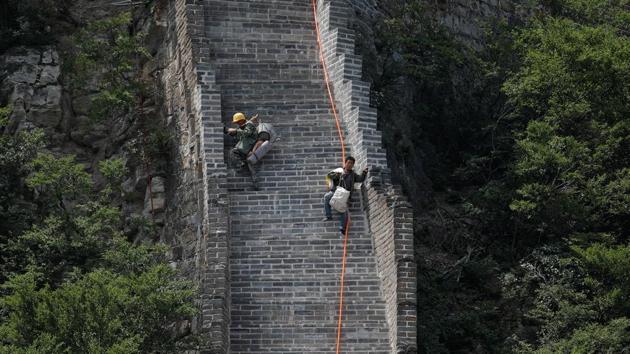 Workers carry their tools and belongings as they climb down the Great Wall. (Damir Sagolj/REUTERS) Workers carry their tools and belongings as they climb down the Great Wall. (Damir Sagolj/REUTERS)