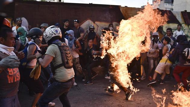 This file photo taken on May 20, 2017 shows opposition demonstrators set an alleged thief on fire during a protest against the government of President Nicolas Maduro in Caracas. It is not just Venezuela's economy and political system that are sick, experts say -- but society itself. (AFP Photo) This file photo taken on May 20, 2017 shows opposition demonstrators set an alleged thief on fire during a protest against the government of President Nicolas Maduro in Caracas. It is not just Venezuela's economy and political system that are sick, experts say -- but society itself. (AFP Photo)