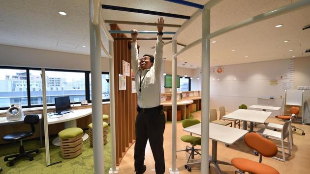 The suited staff are taking part in a regular calisthenics drill implemented by Adoc International, while over at electrical equipment firm Fujikura, the staff can be seen dangling from multi-coloured monkey bars. (KAZUHIRO NOGI / AFP) The suited staff are taking part in a regular calisthenics drill implemented by Adoc International, while over at electrical equipment firm Fujikura, the staff can be seen dangling from multi-coloured monkey bars. (KAZUHIRO NOGI / AFP)