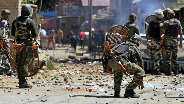 CRPF personnel face protesters throwing stones on them during a protest at Arwani village of Anantnag district of south Kashmir on Friday.(PTI)
