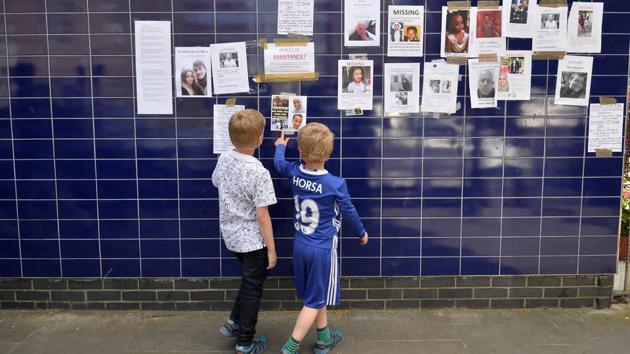 Two boys look posters of people missing in the Grenfell apartment tower block fire in North Kensington, London, Britain, June 17, 2017.(REUTERS Photo)