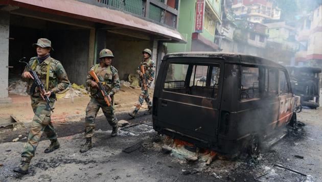 Soldiers patrol near burnt out vehicles after clashes with supporters of the separatist Gorkha Janmukti Morcha (GJM) group in Darjeeling on June 17, 2017.(AFP Photo)