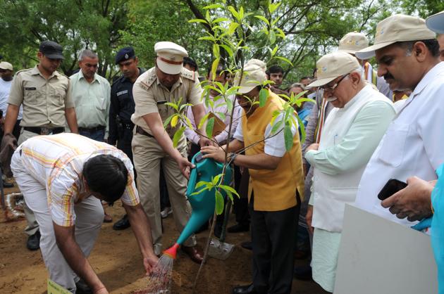 Union minister for environment Dr Harsh Vardhan (in jacket) plants a sapling in Bhondsi village on Saturday.(Parveen Kumar/HT Photo)