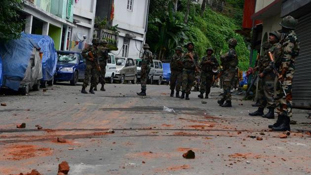 Soldiers patrol next to remains of bricks thrown by supporters of the Gorkha Janmukti Morcha (GJM) group after clashes in Darjeeling.(AFP Photo)