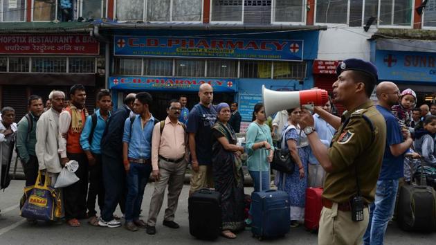 A policeman uses a megaphone to organise queues of tourists waiting to leave amid clashes between security personnel and protesters after the Gorkha Janmukti Morcha (GJM) called an indefinte strike in Darjeeling. (AFP) A policeman uses a megaphone to organise queues of tourists waiting to leave amid clashes between security personnel and protesters after the Gorkha Janmukti Morcha (GJM) called an indefinte strike in Darjeeling. (AFP)