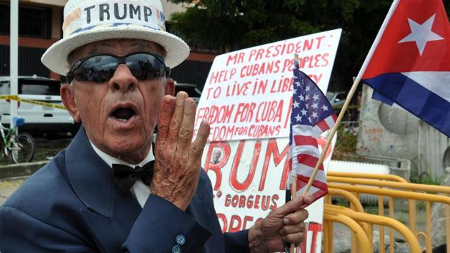 A man holds signs referencing US President Donald Trump's policy on Cuba in Miami, Florida. (AFP) A man holds signs referencing US President Donald Trump's policy on Cuba in Miami, Florida. (AFP)