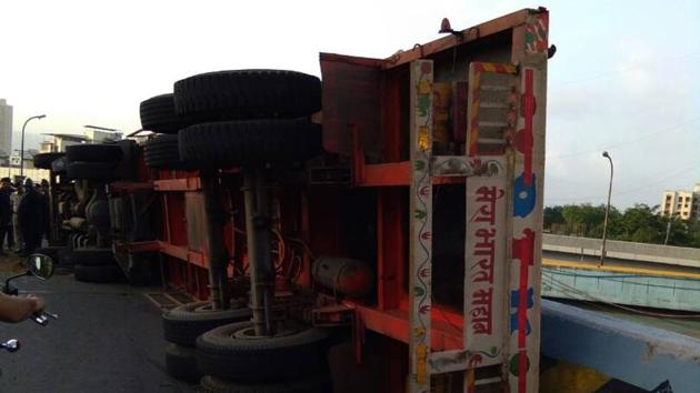A container toppled on the Majiwada flyover early on Monday. (HT Photo) A container toppled on the Majiwada flyover early on Monday. (HT Photo)