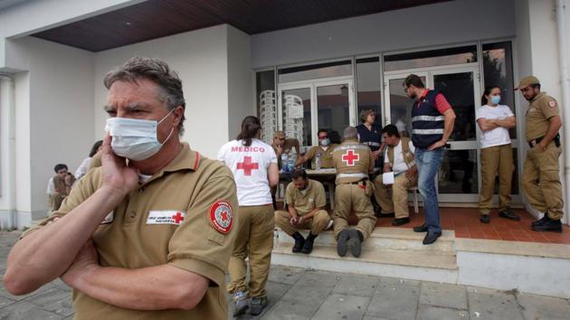 Red Cross and other relief personnel are seen outside a relief centre for people affected by the forest fire. (Miguel Vidal/REUTERS)