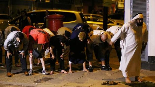 Men pray near the scene of the accident after a vehicle collided with pedestrians near the mosque. (REUTERS) Men pray near the scene of the accident after a vehicle collided with pedestrians near the mosque. (REUTERS)