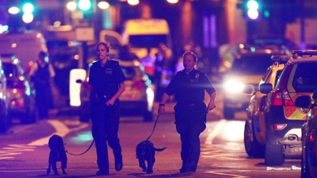 Police officers with sniffer dogs patrol the streets of North London. (REUTERS) Police officers with sniffer dogs patrol the streets of North London. (REUTERS)
