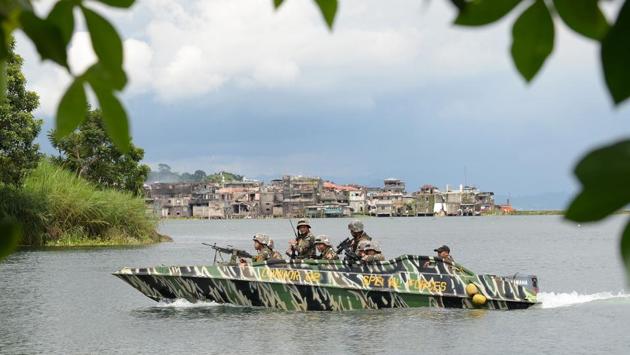 Members of the Philippine Army patrol in a speedboat across a lake near Marawi. The military has declared that  257 of the total 600 terrorists have already been killed while the remaining were blending with refugees to cross the border. (AFP) 