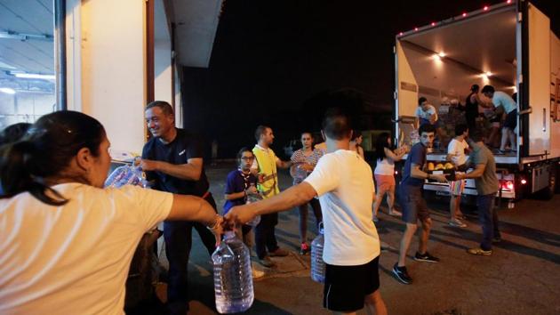 Volunteers unload food and water at a fire station in Portugal. (REUTERS)