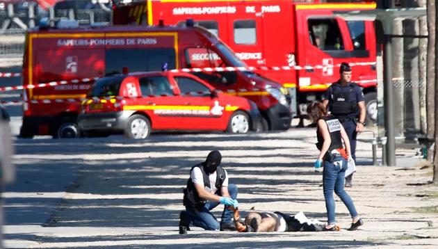 Criminal police inspect the body of a suspect at the scene of an incident in which a car rammed a gendarmerie van on the Champs-Elysees Avenue in Paris, France, June 19, 2017. (REUTERS) Criminal police inspect the body of a suspect at the scene of an incident in which a car rammed a gendarmerie van on the Champs-Elysees Avenue in Paris, France, June 19, 2017. (REUTERS)