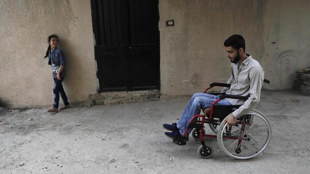 Adnan(R), 19 who was shot in the spine from a sniper in 2013 as he was crossing a bridge on his bike to bring bread to his family in Homs province, pushes his wheelchair at a small alley back to his home. Adnan is now paralyzed from the waist down although operations and physiotherapy enabled him to strengthen his upper body to adjust to the new life. (AP)