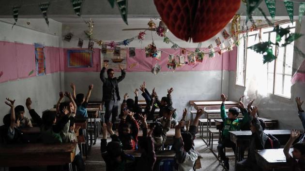 A member of the Syrian civil defence teaches schoolchildren how to protect themselves in case of an air strike during a war safety awareness campaign. (AFP)