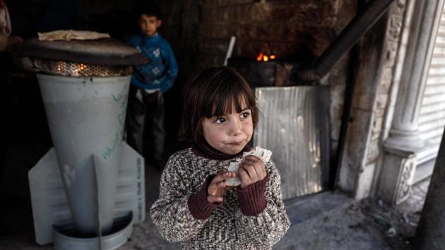A Syrian girl eats a bread which was baked in a makeshift oven using the remains of a rocket on the eastern outskirts of the Syrian capital, Damascus. After six years of conflict, Syrians are facing one of the largest humanitarian crisis in the world with children having paid the ultimate price. According to UNICEF, 2016 was the worst year for Syrian children with more 600 reported dead. Nearly 6 million children are estimated to be dependent upon humanitarian assistance with most of them suffering from war-related trauma in Middle East’s conflict zone. (AFP)