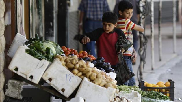 Children buy vegetables at the town of Madaya in the Damascus countryside. (AP)