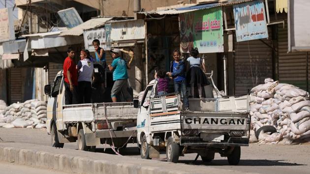 Vehicles carrying children drive past stacked sandbags in the town of Tabqa after Syrian Democratic Forces (SDF) captured it from Islamic State militant forces. (REUTERS)