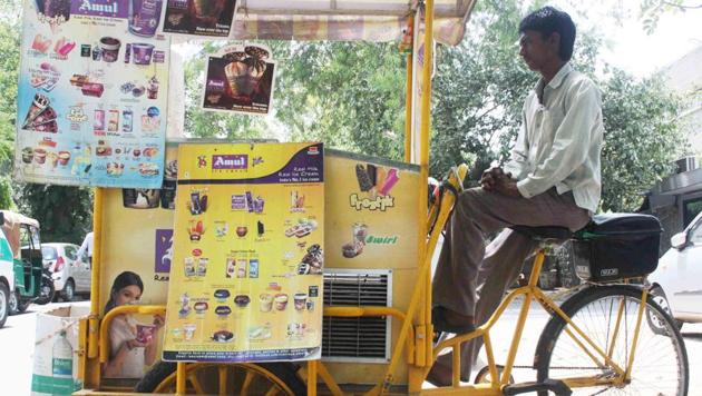 Bimal’s cart is painted yellow. It has posters advertising various ice creams.(Mayank Austen Soofi / HT Photo)