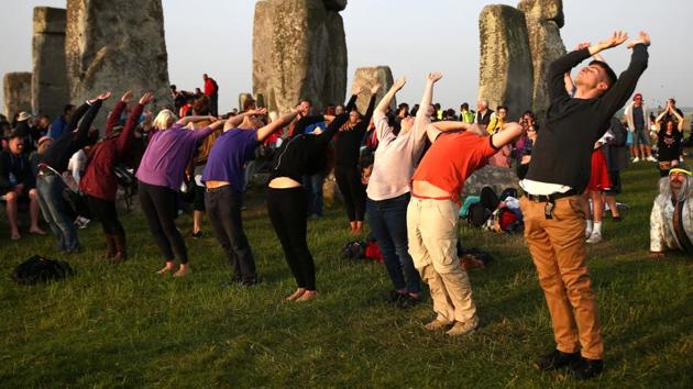 People practice yoga by the Stonehenge at dawn on the Summer Solstice. According to reports, more than 13,000 people had gathered around the historic monument to observe the sunrise. (REUTERS)