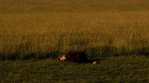 A girl lies asleep by the side of a field near Stonehenge during the pagan festival of Summer Solstice. (AFP)