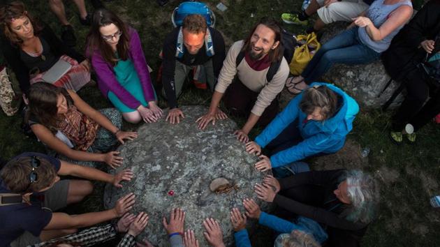 Revellers touch a stone and chant in the stone circle as they celebrate the pagan festival of Summer Solstice at Stonehenge in Wiltshire,England.The festival celebrates the longest day of the year. Possibly built around 5000 years ago, the Stonehenge is believed to have been used to mark solstices and equinoxes. It is said that if one stands at the right spot on the day of the northern summer solstice facing outside the circle -known as the Heel Stone- one can see the sun rise exactly above it. (AFP)