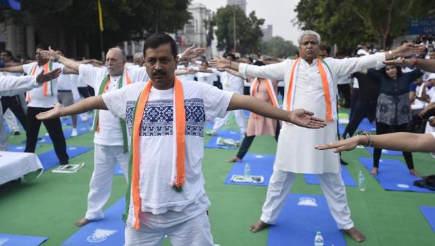 Delhi chief minister Arvind Kejriwal and LieutenantGeneral Anil Baijal during International Day of Yoga celebrations at Connaught Place on Wednesday.(Burhaan Kinu/HT PHOTO)