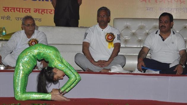 CM Trivendra Singh Rawat (centre) looks on as a child performs on the occasion of International Yoga Day at Parade Ground in Dehradun on Wednesday. (Vinay Santosh Kumar/HT Photo) CM Trivendra Singh Rawat (centre) looks on as a child performs on the occasion of International Yoga Day at Parade Ground in Dehradun on Wednesday. (Vinay Santosh Kumar/HT Photo)